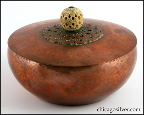 Rebecca Cauman bowl, round, copper, with removable lid, white enameled interior and delicately carved and pierced spherical ivory finial on lid atop centered decoration of applied chased concentric circles with pierced small circles and teardrop shapes.  