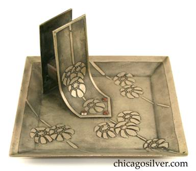 Carence Crafters tray, square, nickel silver (or "German" silver), with upturned edge, upright riveted matchbox holder with arrow-shaped points front and back, curving front surface and straight back.  Very nice acid etched design of blossoms and bamboo-like lines.
