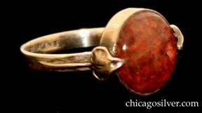 Forest Craft Guild ring, silver, with round bezel-set mottled purple-red Mexican fire opal in circular frame, with small applied leaf and curving stem ornament on either side.