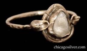 Forest Craft Guild ring, with bezel-set freeform tooth-like fresh-water pearl in conforming silver frame, with small applied stylized leaf ornaments on either side.  Thin shank.