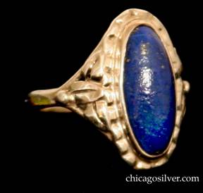 Forest Craft Guild ring, with grooved and worked oval silver frame centering an oval bezel-set deep blue lapis stone.  Three applied stylized leaves and bead ornament on both sides.  Split shank.