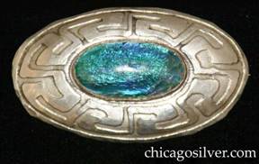 Forest Craft Guild brooch, German silver, with wide convex body acid-etched with geometric design, centering a large oval bezel-set cabochon foil-backed glass stone. 