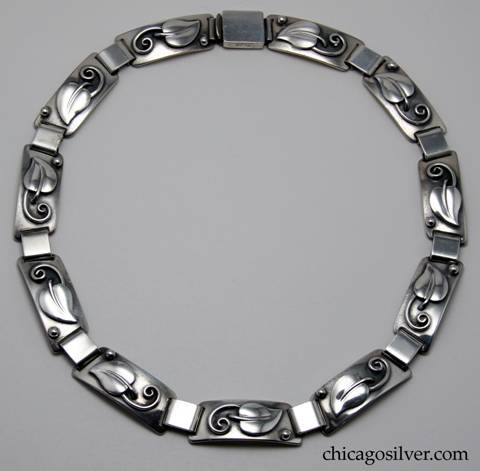 Laurence Foss necklace / choker, composed of eleven graduated trapezoidal links, each with an applied leaf with curving stem and separate bead, joined to the others by thick silver loops.  Spring clasp.