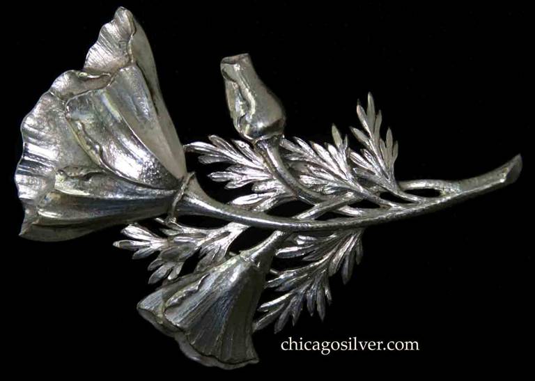 Clemens Friedell Brooch.  Massive  repousse brooch in the shape of a California poppy, with one large blossom, one smaller blossom, and one bud, on an intertwined set of stems and fern-like leaves.  Beautiful, delicate hammering on the flowers.  