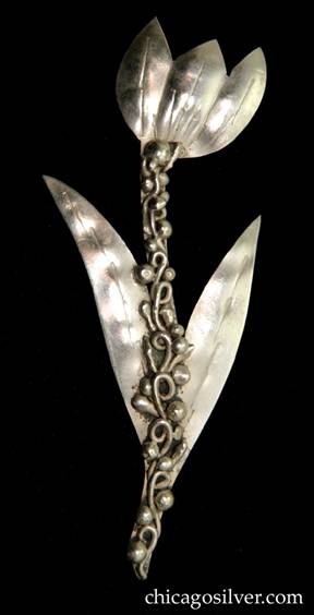 Mary Gage pin, in the shape of a chased and repousse flower with three petals and two long, thin leaves on a stem with applied beads and wires down the center