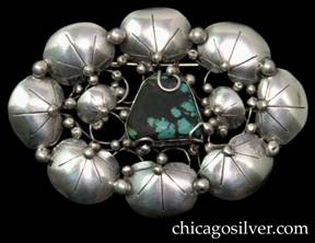 Mary Gage pin, large oval, composed of eight chased lily pads centering two smaller pads that flank a trapezoidal turquoise bezel-set stone