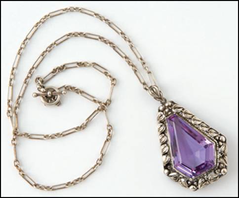 Pendant, 2" H, on silver chain 19" L.  Handwrought in sterling silver by James Scott of the Elverhöj craft community, with elegantly fashioned leaves and beadwork forming a border around a central teardrop-shaped faceted amethyst.  Unsigned.
