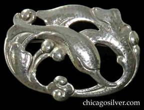 Randahl brooch, oval, with swirling design of leaping dolphin surrounded by waves and beads, on cutout frame.