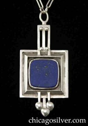 Kalo necklace / pendant, square form with smaller square inside recessed frame, on paperclip chain, centering large square flat blue bezel-set silver-flecked lapis stone with rounded corners, with pierced geometric ornament top and bottom