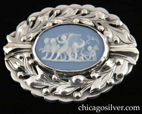 Kalo brooch, oval, dimensional, with scalloped outside frame and smaller oval inside frame centering an oval piece of blue bezel-set Wedgwood with classic motif