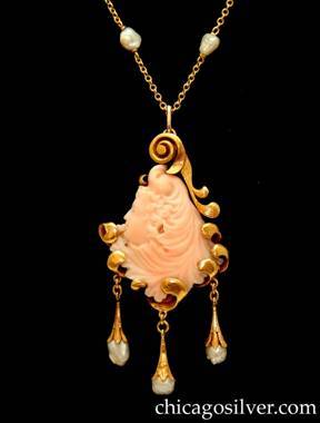 Lebolt pendant on chain, gold, with coral and pearls.  Teardrop-shaped solid 14K back with carved and hand-worked scroll at top and curving loops at the sides and bottom that restrain a carved pink coral stone in the form of a woman's head in profile.  Below are three freshwater pearls in hand-worked gold drops connected by small gold loops.  Pendant is mounted on long delicate 18K gold chain with ten integrated freshwater pearls spaced on its length.