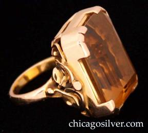 Ring, by Edward Oakes, yellow gold, large and heavy, with a faceted rectangular Minas Gerais Brazilian topaz.   Stone is bezel-set in yellow gold with extensions at the corners, a wirework structure at the back to accommodate the deep stone, and applied curved leaves, beads, and spiraling wire on the sides.  