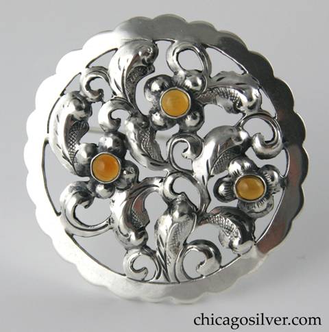 Yngve Olsson round brooch with chased and cutout details and three amber stones