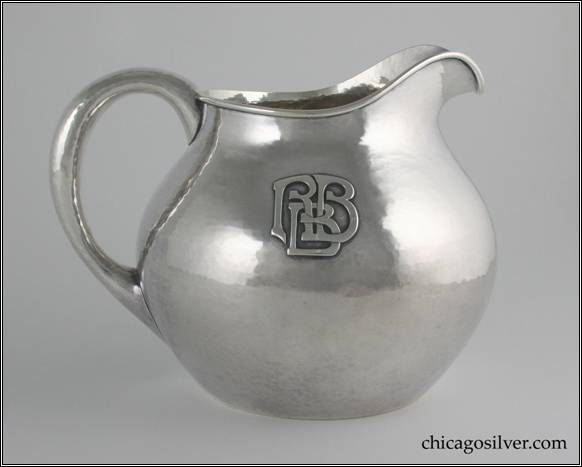 Kalo pitcher, water, squat form, with looping hollow handle, arching spout, bulbous body, small opening with applied wire to rim, applied RBB mono on side.  Nice hammering.  6-1/2" H and 8-3/8" W.  STERLING / HAND WROUGHT / AT / THE KALO SHOPS / CHICAGO / AND / NEW YORK 12