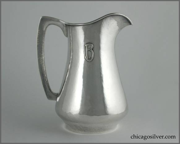 Kalo pitcher, water, with flat bottom and high spout.  Nice, angular hollow handle.  Hammered surfaces and applied block B mono.  8" H and 7" W.  STERLING / HAND WROUGHT / AT / THE KALO SHOP / 10P