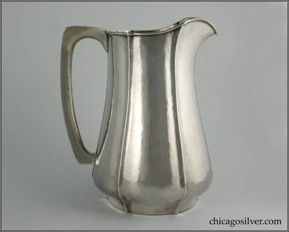 Kalo pitcher, water, with flat bottom, applied wire on rim and fluted sides, nice angular hollow handle.  Hammered surfaces.  Duplicate form to one shown full page (#49) in Sharon Darling's "Chicago Metalsmiths" book.  7" W and 8-1/2" H.  STERLING / HANDWROUGHT / AT / THE KALO SHOP / 10