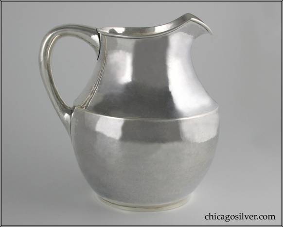 Kalo pitcher, on small ring self-foot, with body flaring outward from foot to just above middle, then tapering inward with narrow neck and v-shaped upward-pointing spout.  Applied wire to rim.  Small looping hollow handle, lightly engraved E-B-R mono on side.  7" W and 7-1/2" H.  STERLING / HAND BEATEN / AT / KALO SHOPS / PARK RIDGE / ILLS. / 9317
