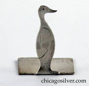Potter Studio place card holder in the form of a bird handwrought in sterling silver with chased details and a split rectangular base that has an upright prong for holding a place card