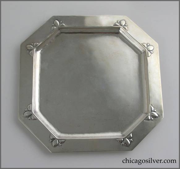 Kalo tray, octagonal, round, with flat bottom, alternating long and short sides and a slightly raised border with repouss stylized floral design at each of the eight corners