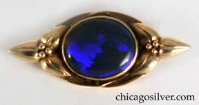 Margaret Rogers pin, gold, oval, small, with applied trefoil leaves and berries at each end and purple cabochon bezel-set black opal in the center.  