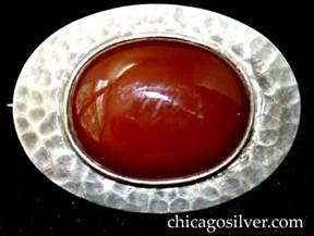 Art Silver Shop brooch / pin, oval, with flat hammered edge and large oval bezel-set cabochon carnelian stone at center.  Heavily hammered surfaces.