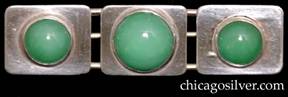 Brooch / pin, composed of three rectangular plaques with rounded corners, each centering a round bezel-set green stone, all of which are mounted on an oval wire frame.  The stone on the center plaque is larger than the ones at the ends.