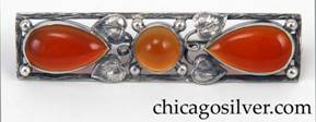 Brooch, silver, rectangular frame with orange translucent tear-shaped bezel-set cabochon stones and a similar round stone at center, with leaves, curling silver stems and silver bead ornament.  Frame is worked to look like wood grain.